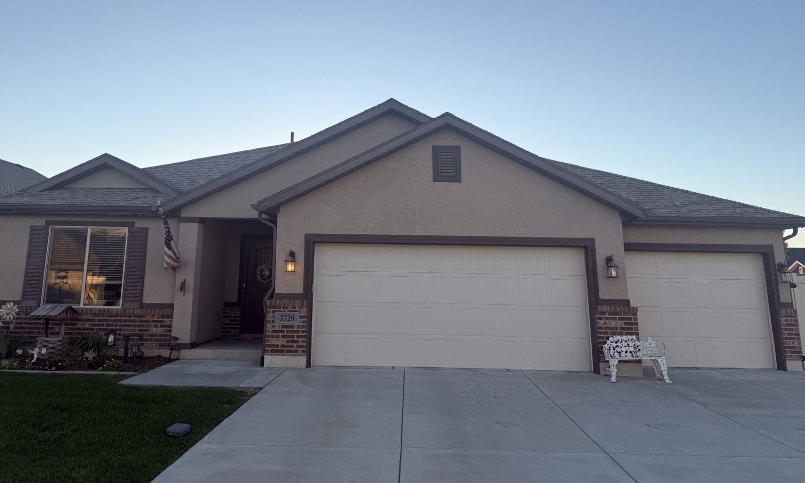 Before: a single-story stucco rambler at dusk with the lights off